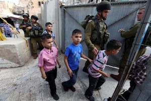 Soldati israeliani vigilano un gruppo di bambini palestinesi che sono stati arrestati nel primo giorno dell'Eid al-Fitr in Hebron, Cisgiordania, per giocare con le loro armi giocattolo  Foto: EFE/ABED AL HASHLAMOUN